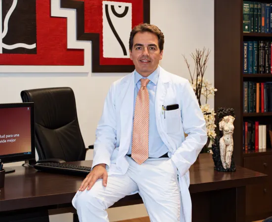 Dr. José Ángel Lozano Orella con bata blanca en su consulta de cirugía plástica en Pamplona